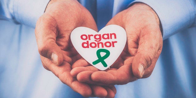 A reminder of the importance of organ donation. Male hands holding heart with a message that reads: Organ donor.