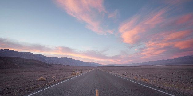 a straight road in death valley at sunset