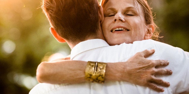 Close-up of a happy mature woman hugging a man at a garden party