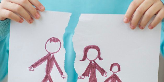 Girl holding drawing of split family