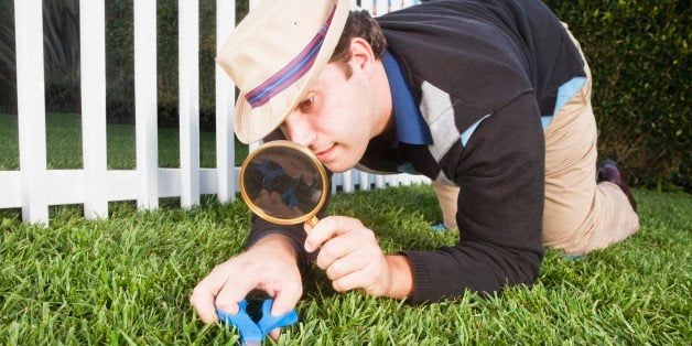 Man cutting grass with scissors