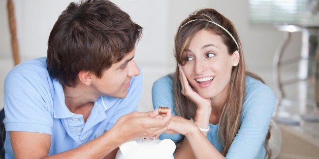 A young couple lying on the floor counting coins