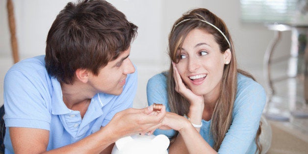 A young couple lying on the floor counting coins