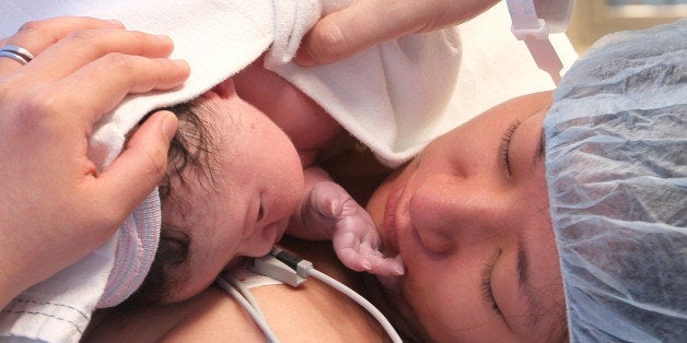 BOSTON - OCTOBER 20: Nicole Xu gets her first look at her newly born son after having a c-section Monday morning at Brigham and Women's Hospital, her husband Chris Anzivino hand holds the baby at right. (Photo by Joanne Rathe/The Boston Globe via Getty Images)