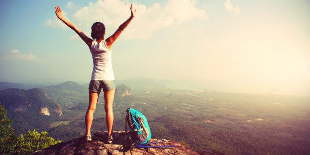 woman hiker enjoy the view at landscape on mountain peak cliff