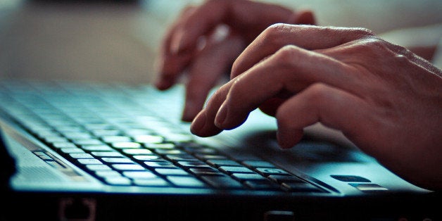 Women is writing on laptop keyboard.