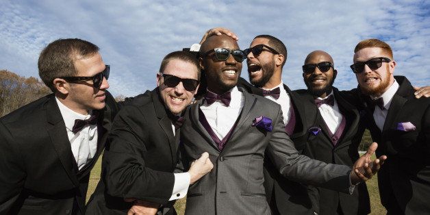 Groom and groomsmen posing for wedding pictures