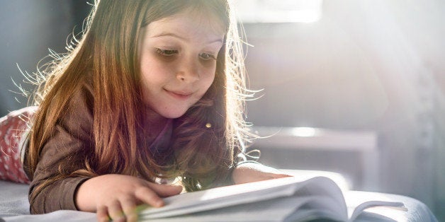 Cute Girl Reading a Book at Home