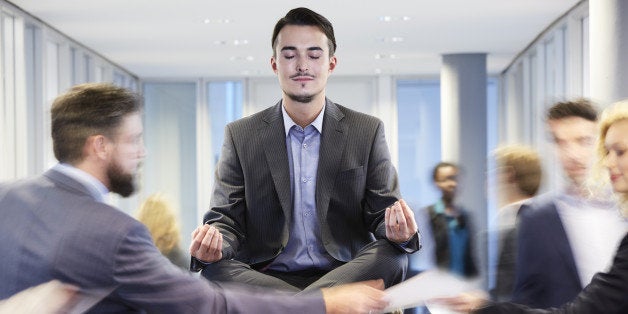 Germany, Neuss, Business man meditating on desk