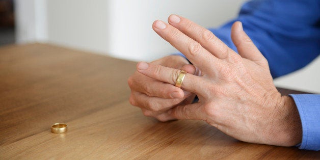 Mature man holding wedding ring, close up