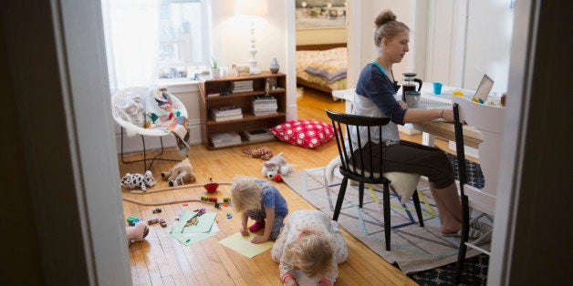 Mother working from home while children play