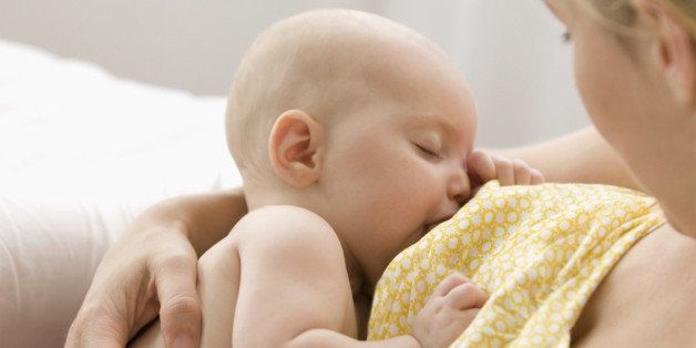 Caucasian mother breast feeding baby boy