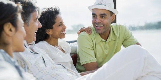 Smiling mature couples sitting on patio at resort