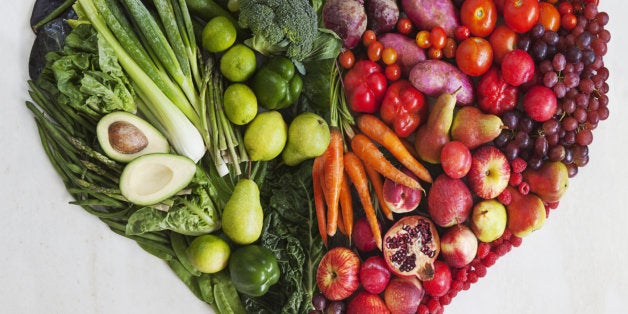 Variety of fresh red & green vegetables & fruit in heart shaped still life.