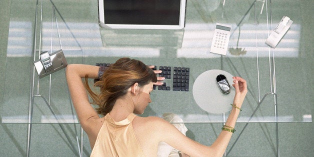 Woman leaning head on desk with futuristic devices, high angle view