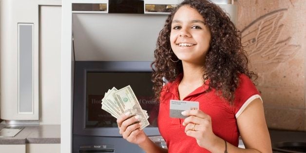 African teenage girl holding money and credit card