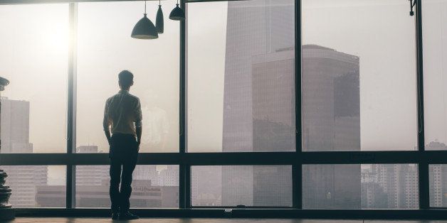 Businessman looking at cityscape from office