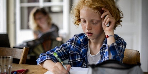 Swiss boy Leon, 9, does his homework on June 20, 2013 in his home in Moudon, western Switzerland. AFP PHOTO / FABRICE COFFRINIRESTRICTED TO EDITORIAL USE (Photo credit should read FABRICE COFFRINI/AFP/Getty Images)