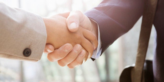 Businessman shakes hand of businesswoman, close up