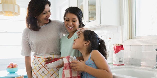 Mother and daughters hugging in kitchen