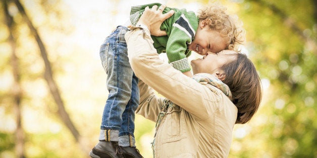 Mother and son enjoying a sunny day in a park, holding each other joyfully