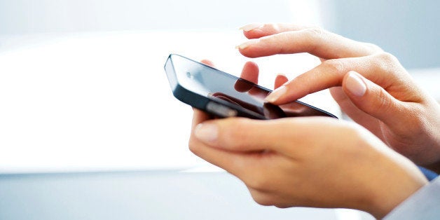 Businesswoman typing on cell phone