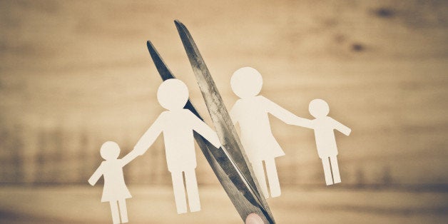 Hand with scissors cutting paper cut out with family member shape / Family problem / Divorce concept