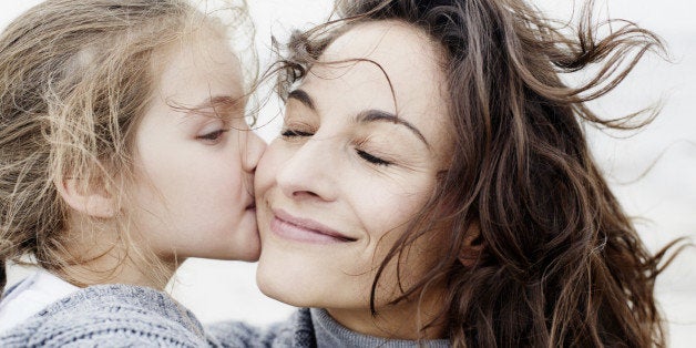 Daughter kissing mother outdoors