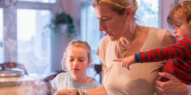 Caucasian mother and children cooking in kitchen