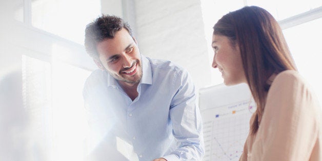 Smiling businessman and businesswoman in conference room