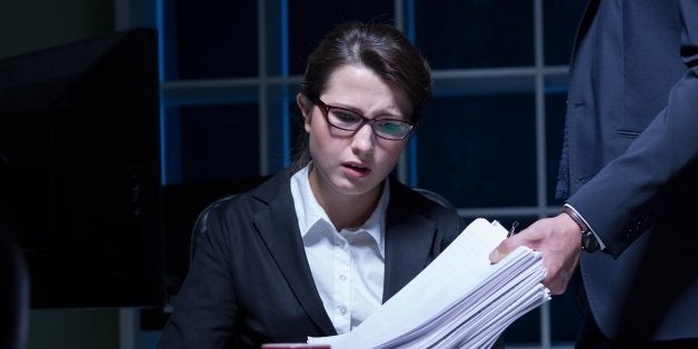 Sleepy woman working overtime in office