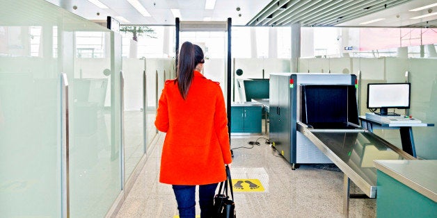 Female passenger walking through the airport security checkpoint