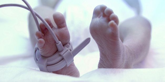Feet of new born baby under ultraviolet lamp in the incubator