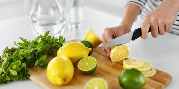Healthy Food And Eating. Closeup Of Woman In The Kitchen Cutting Lemons And Limes. Healthy Lifestyle. Citrus Fruits. Vitamin C. Detox Water. Lemonade. Diet. Dieting Concept.