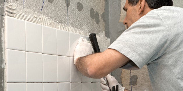 man setting tile on cement...