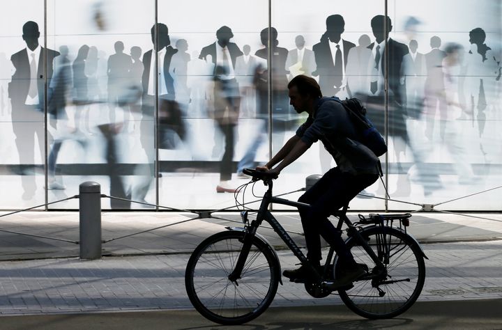 A man rides a bicycle past a building of the European Commission in Brussels