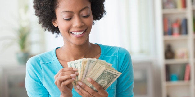 African American woman counting money in living room