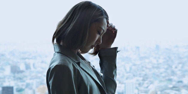 Depressed young woman,cityscape in background