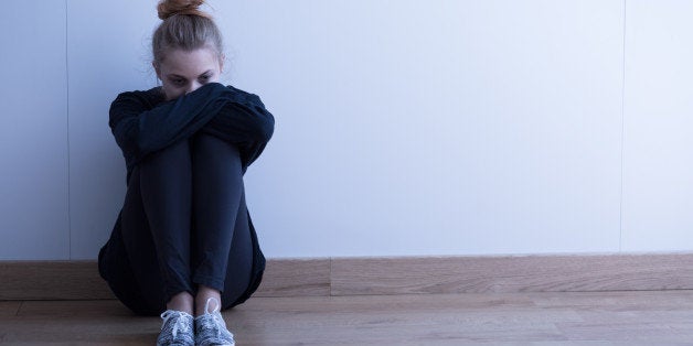 Sad woman with depression sitting on the floor