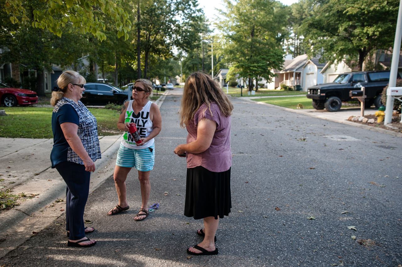 Pat Williams (left), Sally Leeman and Shannon Hicks gather in front of their homes to talk about the rising Cape Fear River, directly behind their neighborhood.