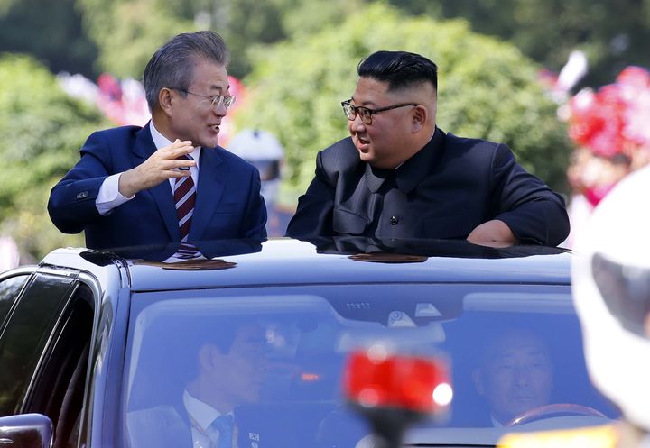 South Korean President Moon Jae-in, left, and North Korean leader Kim Jong-un ride in a car parade in Pyongyang on Tuesday.