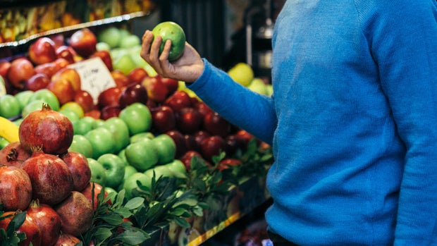 A man shopping some fruits.