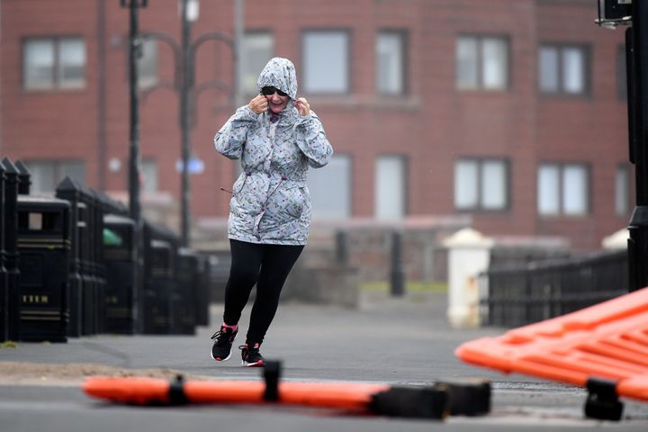 A woman struggles in the wind in Saltcoats, Scotland 