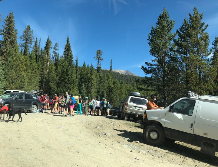 The crowded parking area at the start of the Fancy Lake trail this month. Towns and counties in the area are pitching in to help the Forest Service manage the summer crowds. 