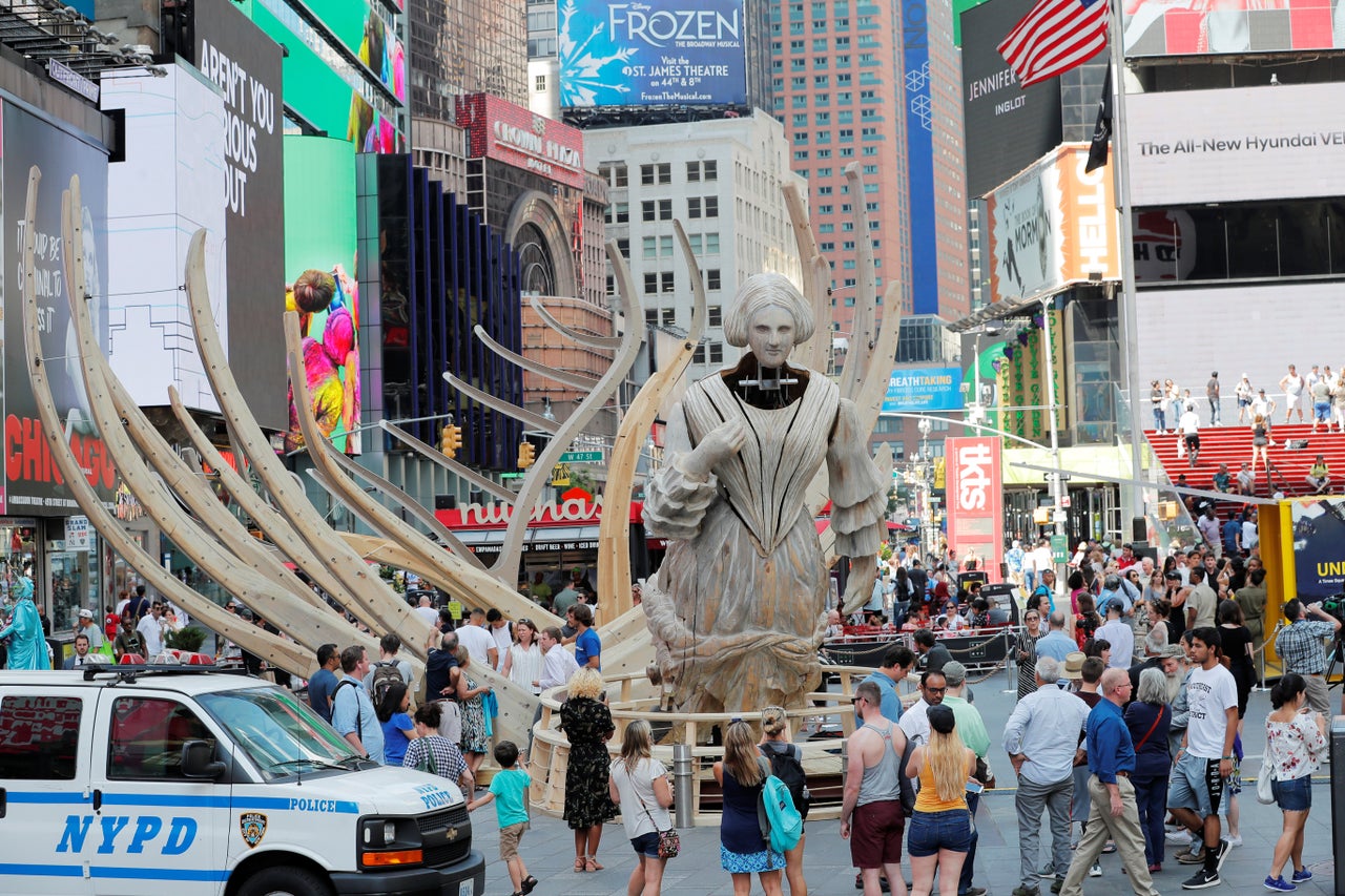 Pedestrians walk past artist Mel Chin's mixed reality climate change themed art installation, "Unmoored," in New York City on July 11, 2018.