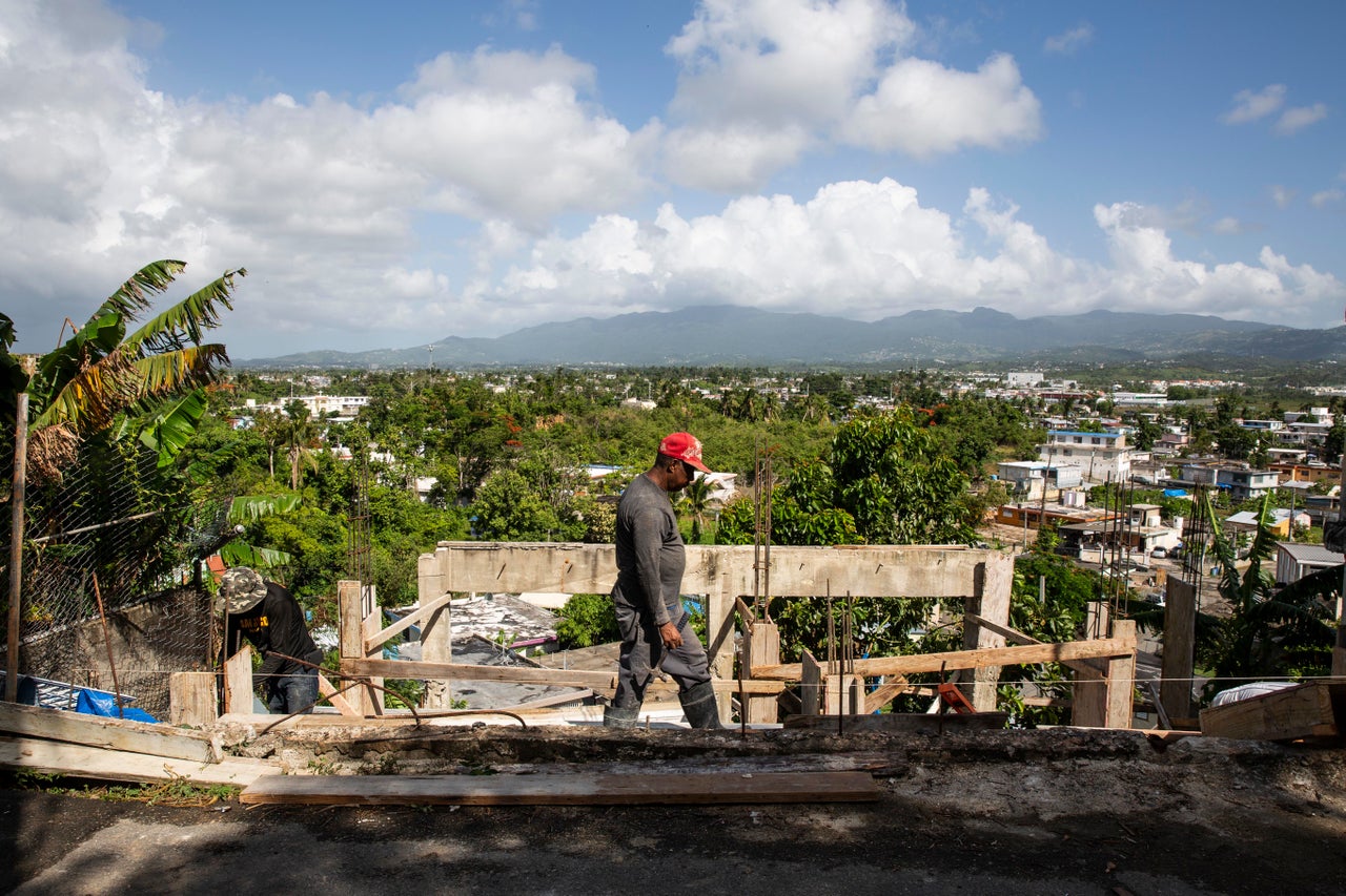 Workers rebuild a home in Villa Hugo 2 nearly a year after the storm.