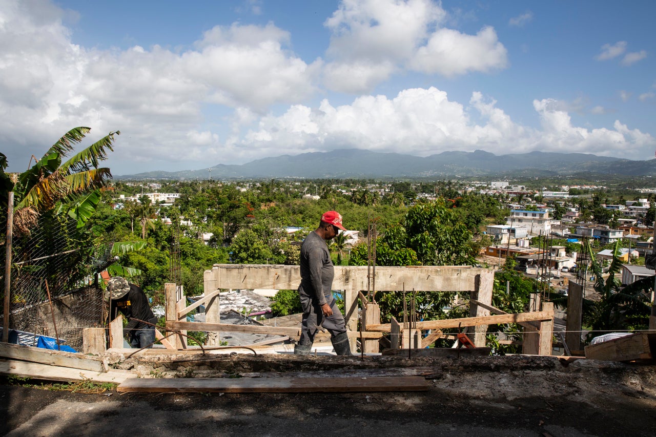 Workers rebuild a home in Villa Hugo 2 nearly a year after the storm. 