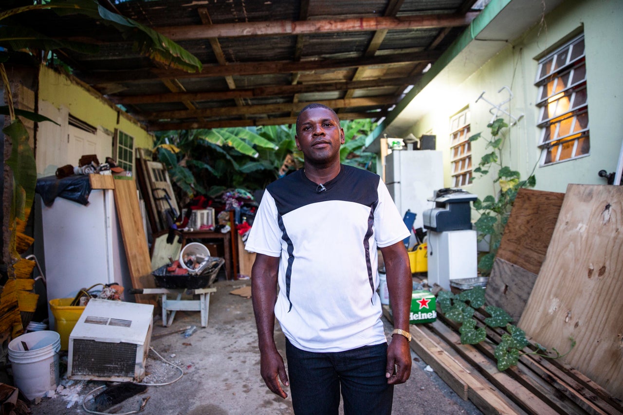 A more optimistic Medina-Dishmey stands in his driveway almost a year after Maria. He's still hoping that some kind of aid will help him to finish fixing up his home.