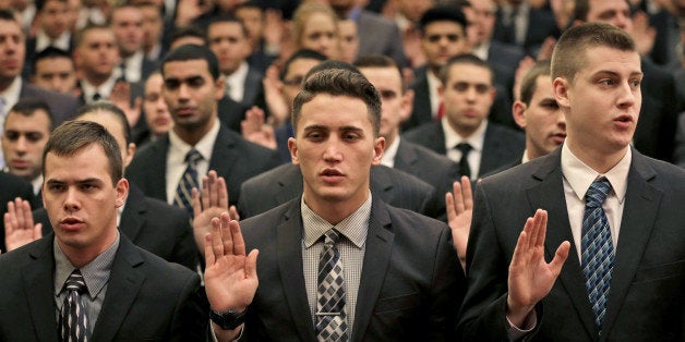 New York Police Department recruits take an oath during an NYPD swearing-in ceremony in New York, Wednesday, Jan. 7, 2015. M