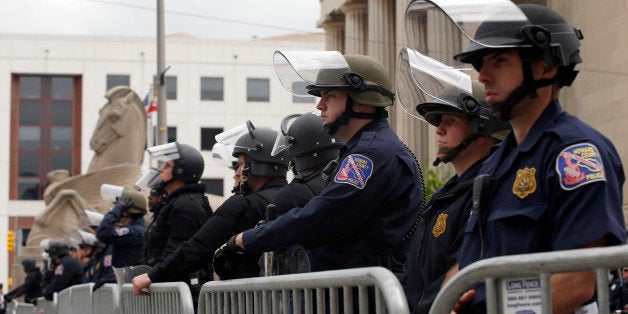 Police officers stand guard with the War Memorial behind, Friday, May 1, 2015 in Baltimore. State's Attorney Marilyn J. Mosby announced criminal charges Friday, against all six officers suspended after Freddie Gray suffered a fatal spinal injury in police custody in Baltimore. (AP Photo/Alex Brandon)